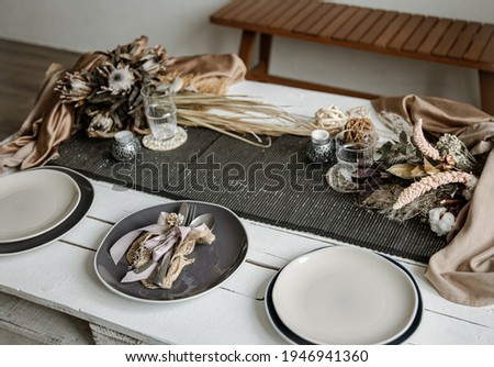 Stylish crockery and cutlery on a set table in coffee colors with Scandinavian-style decorative elements.