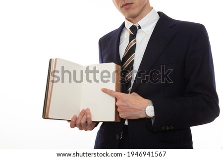 A business person who opens a book and points to the contents