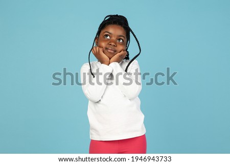 Handsome african little girl portrait isolated on blue studio background with copyspace