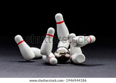 Bowling. Bowling ball knocks down pins on a black background. Copy space. Space for text