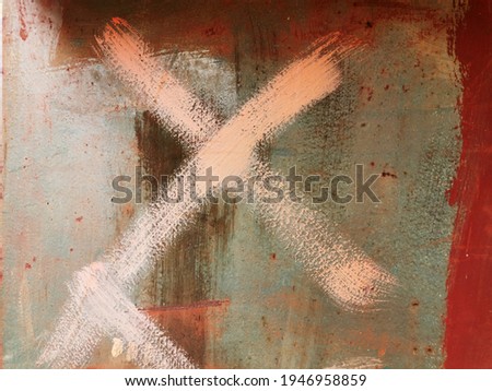 old red metal wall with corrosion and rust stained with multi-colored paint, on which the x sign is painted