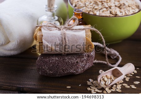 Spa setting with oat flakes on  wooden background. Soap, pumice, aroma oil. Selective focus, horizontal.