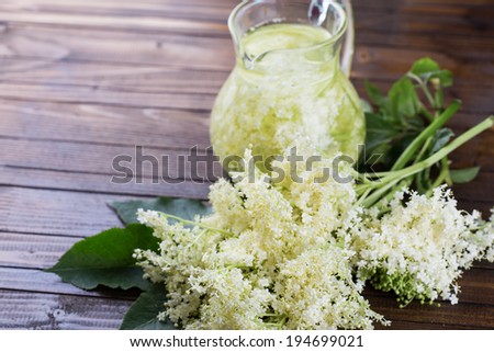 Sambucus flowers and juice  on wooden background. Selective focus, horizontal.