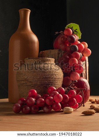 still life with a clay pot and grapes and an apple
