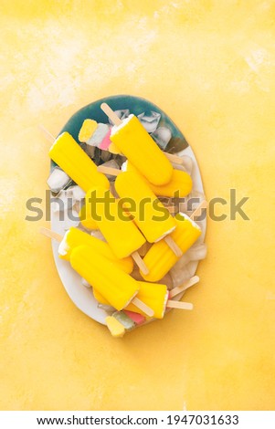Fruity popsicles. Vegan various colorful ice lollies on a plate. Top view, blank space  