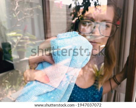 Woman holding rag for cleaning the window.
