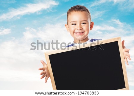 portrait of a cute kid holding a chalkboard