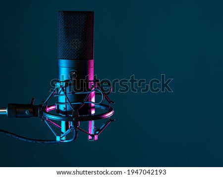 Professional studio microphone. Condenser microphone on a dark background. It is designed for podcasting. Microphone as a symbol for recording audio podcasts. Recording audio podcasts in studio