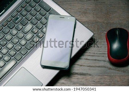 Flat lay, computer mouse, smartphone and laptop on wooden table, copy space.