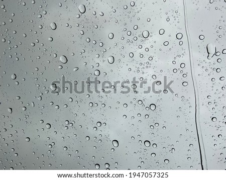Droplet of water on car mirror with blur background