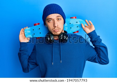 Hispanic young man holding skate depressed and worry for distress, crying angry and afraid. sad expression. 
