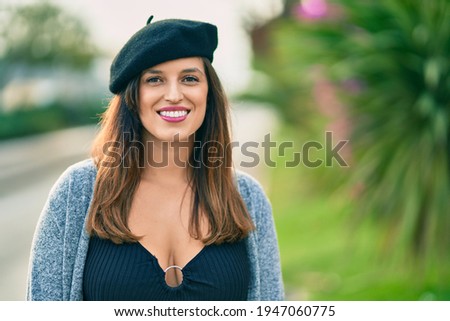 Young latin woman wearing french style standing at the city.