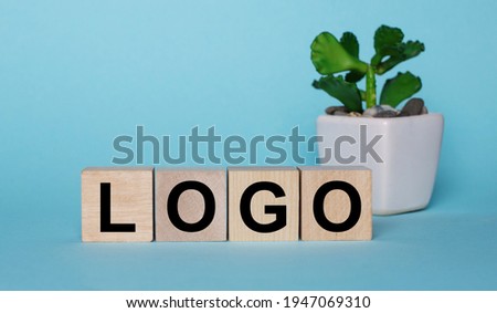 On a blue background, on wooden cubes near a plant in a pot LOGO is written