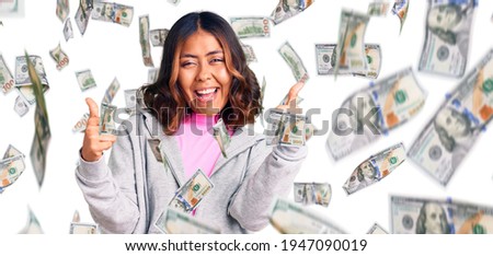 Young beautiful mixed race woman wearing casual sporty clothes success sign doing positive gesture with hand, thumbs up smiling and happy. cheerful expression and winner gesture.