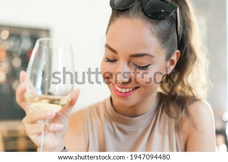 Portrait of gorgeous young brunette tourist woman having white wine.