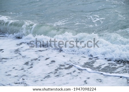 Seascape of gently undulating sea and waves with white foam. Blue and sometimes turquoise cold North Sea. Air is cool and fresh. Minimalistic ocean background.