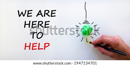 Support symbol. Businessman writing 'we are here to help', isolated on beautiful white background. Light bulb icon. Business and support concept. Copy space.