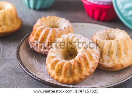 Homemade mini bundt cakes with powdered sugar on gray background Royalty-Free Stock Photo #1947157825