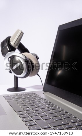 home work, professional condenser microphone, computer and headset on light background, Selective focus on the computer enter key.