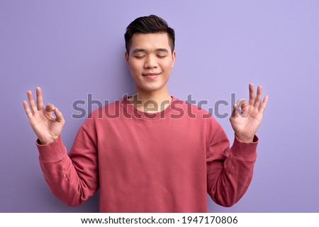 calm asian male meditating, keep calm in yoga pose with eyes closed
