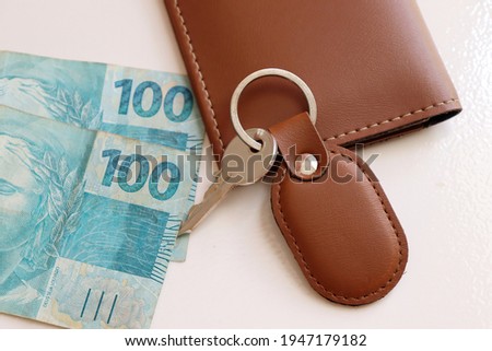 Brazilian money and house keys on top of wallet. Renting a property or mortgage concept.
