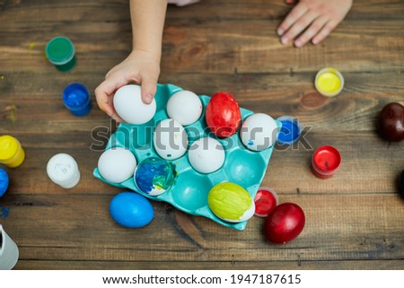 Happy Easter! Painting eggs. Paints, felt-tip pens, decorations for coloring eggs for holiday. Creative wooden background. Family with kids preparing for Easter