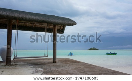 Swing on a tropical beach. isolated idyllic island with boats in the background
