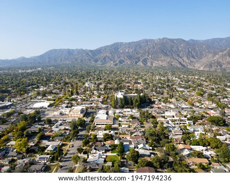 Aerial view above Pasadena neighborhood with mountain in the background. northeast of downtown Los Angeles, California, USA Royalty-Free Stock Photo #1947194236