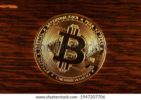 Gold Bitcoin physical coin on wooden Background. Shining digital currency coin. Cryptocurrency the modern digital currency. Bitcoin coin. Futuristic Economy