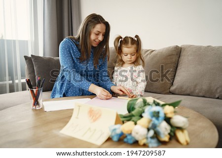 Mom and daughter draw a picture at home