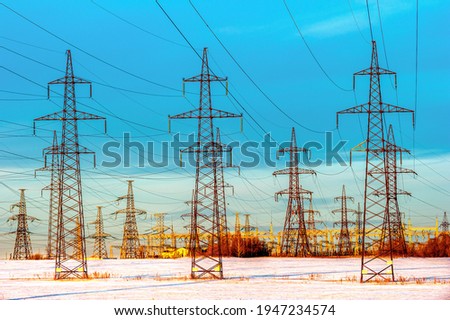High-voltage power line with wires on a blue sky background. Energy industry, power supply, electric tower, supports, poles. Sale of electricity.
