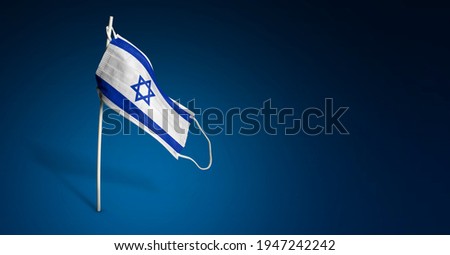 Israel mask on dark blue background. Waving flag of Israel painted on medical mask on pole. Virus Attack flag. Concept of The banner of the fight against the epidemic coronavirus COVID-19. Copy space Royalty-Free Stock Photo #1947242242