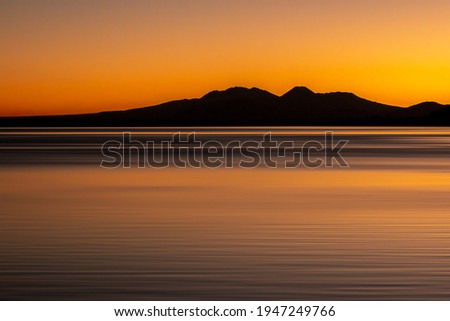 Long exposure of the three Central Plateau volcanos in the desert road silhouetted towering above Lake Taupo New Zealand as night falls Royalty-Free Stock Photo #1947249766