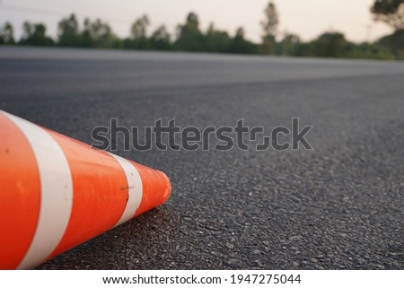 Red rubber cones are placed in the paved road. For safety on the road