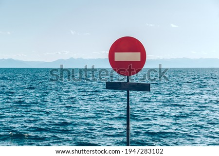 The movement of vehicles is prohibited. Road sign on the background of the sky and the ocean. Prohibition sign. Stop.