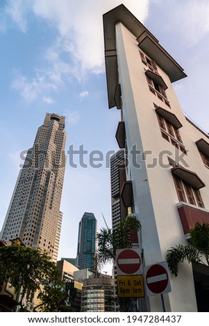 Modern skyscrapers of the business district contrast with colonial architecture in Singapore Boat quay area in Southeast Asia. Royalty-Free Stock Photo #1947284437