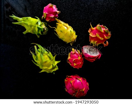 Red and yellow pitayas on a dark background viewed from top to bottom