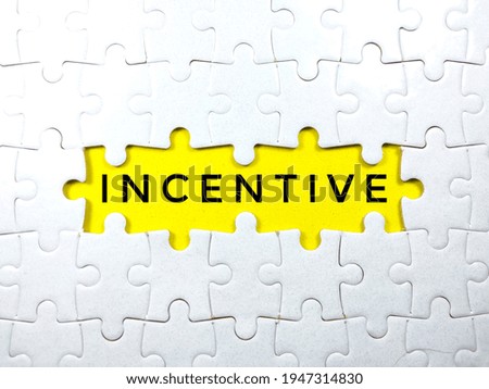 Selective focus.Word INCENTIVE with jigsaw puzzle on yellow background.Business concept.