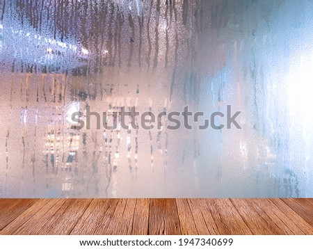 Empty wooden table for displaying products. 
On a rainy day, seeing a drop of water on the outer glass blurred.(Background, rainy day window)
With copy space.