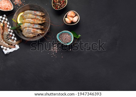 Raw pacific white prawns on dark background. Fresh seafood concept. Top view, copy space