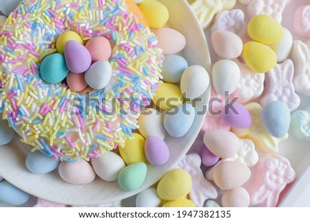 Happy Easter concept. Pastel colored chocolate and donut on white background.