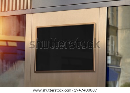 Metal bronze frame hanging in street mockup. Template of a billboard on a wall bathed in sunlight 3D rendering