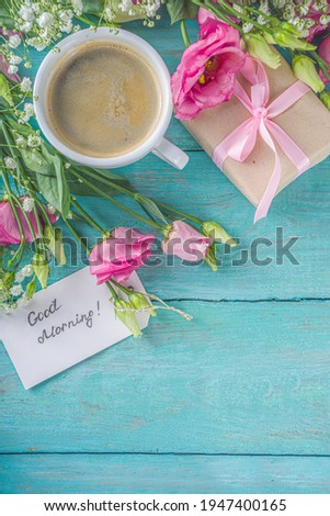 Bouquet of spring, summer flowers, coffee cup and notes good morning, have a nice day on blue wooden table. Summer morning beautiful breakfast, greeting card, top view, flat lay. Mother day concept