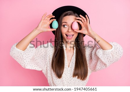 Photo of pretty impressed young lady wear white outfit cap easter eggs close eye isolated pink color background