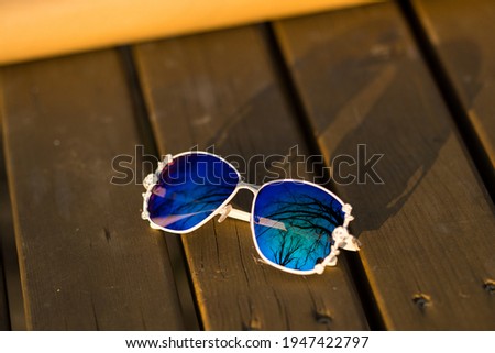 Fashion Sunglasses model with big blue lenses for women with a special design shoot outside in nature in a summer day . Selective focus 