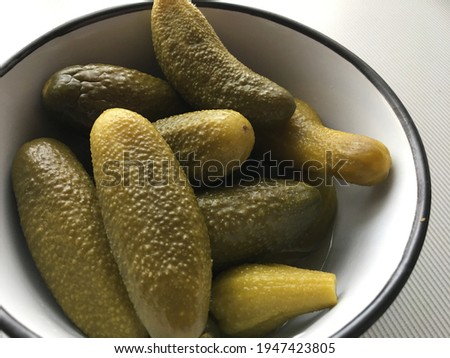 pickled cucumbers close-up lie in a bowl with black edges