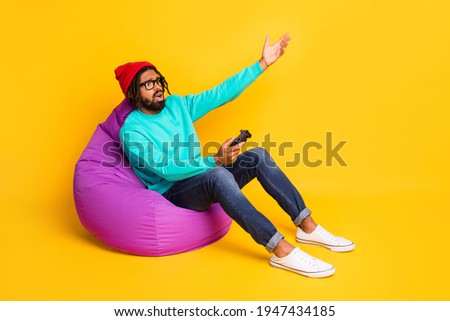 Full size profile photo of brunette sad guy playstation wear cap spectacles pullover jeans isolated on yellow background