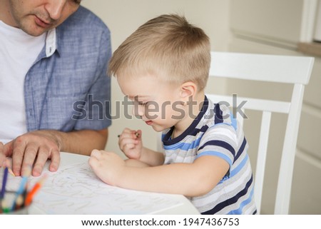 Happy family. Father and son are drawing together. An adult man is engaged with his son. cute kids doing arts and crafts at home