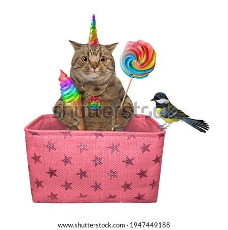 A beige caticorn with a cone of ice cream and a candy is inside a pink gift box. White background. Isolated.