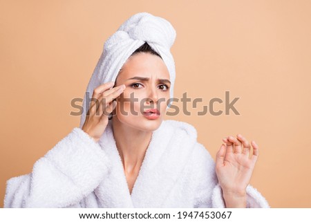 Portrait of pretty worried dreamy girl wear bathrobe touching sensitive skin dark spot isolated over beige pastel color background Royalty-Free Stock Photo #1947453067